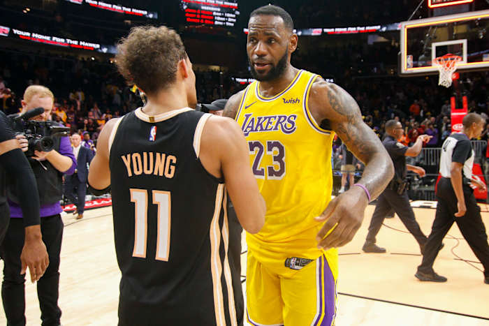 Lakers forward LeBron James talks to Hawks guard Trae Young.